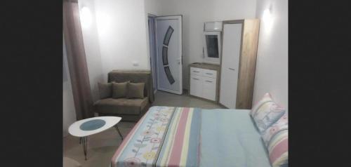 - une chambre avec un lit, une chaise et un miroir dans l'établissement Andjela, à Ulcinj