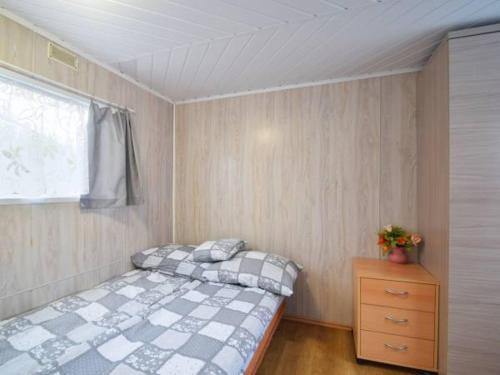 a bedroom with a bed and a window and a dresser at Domek Holenderski in Mielno