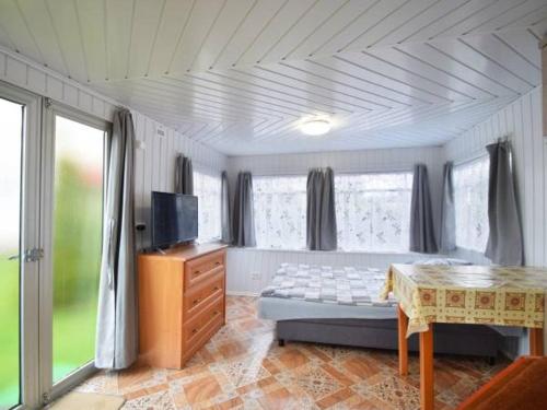 Schlafzimmer mit einem Bett, einem Tisch und Fenstern in der Unterkunft Domek Holenderski in Mielno