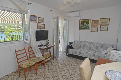 ein Wohnzimmer mit einem Sofa und einem TV in der Unterkunft Veronika in Drvenik Veli