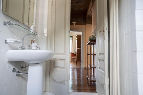 a white bathroom with a sink and a hallway at Villa Cecilia - pieds dans l'eau in Sulzano
