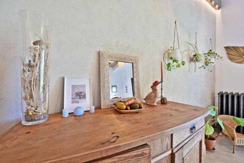 a wooden table with a bowl of fruit and a mirror at Le CAMPAGNE in Beaucaire