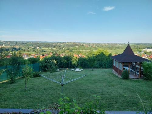 a large yard with a clock in the grass at Manor Villa in Hévíz