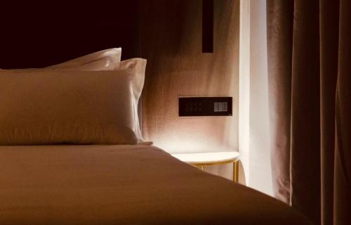 a bed in a room with a clock on the wall at Boutique Hotel Sirmione in Sirmione