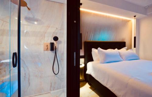 a bedroom with a bed and a glass shower at Boutique Hotel Sirmione in Sirmione