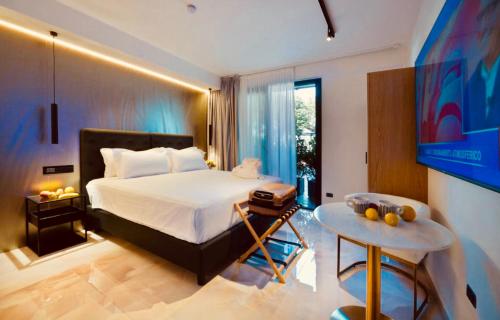 a bedroom with a bed and a table and a tv at Boutique Hotel Sirmione in Sirmione