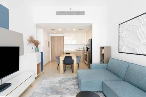 a living room with a blue couch and a table at Nice 1Bedroom - UNA Townsquare in Dubai