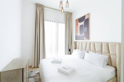 a bedroom with a white bed and a window at Nice 1Bedroom - UNA Townsquare in Dubai