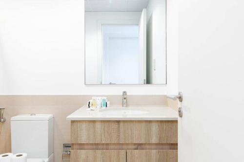 a bathroom with a sink and a mirror and a toilet at Nice 1Bedroom - UNA Townsquare in Dubai