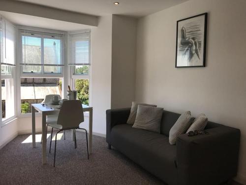 sala de estar con sofá y mesa en Modern Studio Apartment with harbour views, en Penzance