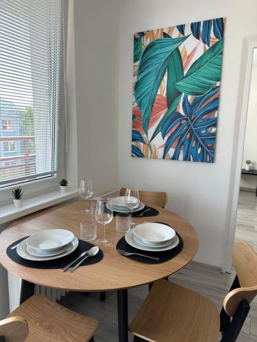 a dining room table with plates and wine glasses at Apartman city center Zvolen in Zvolen
