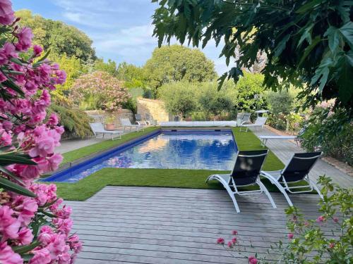 - une piscine dans une cour agrémentée de chaises et de fleurs dans l'établissement Gites au Château des Estubiers, à Les Granges-Gontardes