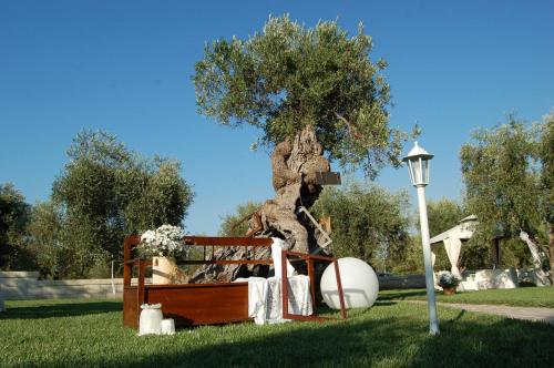 a tree sitting next to a bed in a park at Tenuta Verdolivo in Ostuni