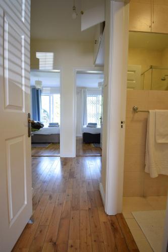 a bathroom with a wooden floor and a room with a tub at 27 Cill Ard Bohermore galway in Galway
