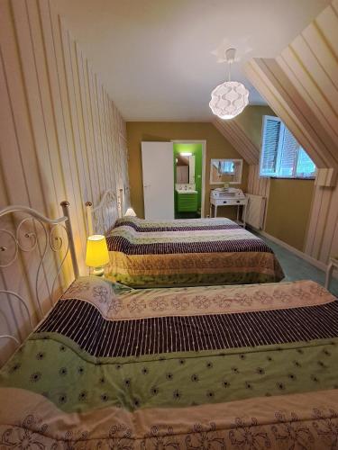 a couple of beds in a room at Chambres d'hôtes le haut de la lande in Crollon