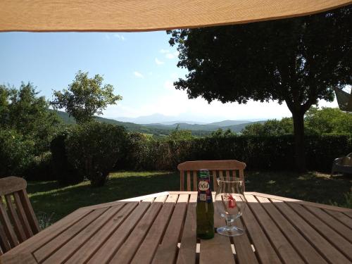 Una botella de vino y dos copas en una mesa de madera. en Au Repos, en Tréziers