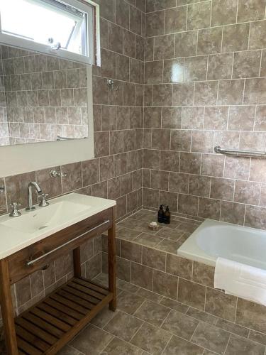 a bathroom with a sink and a bath tub at Refugio de Glaciares in El Chalten
