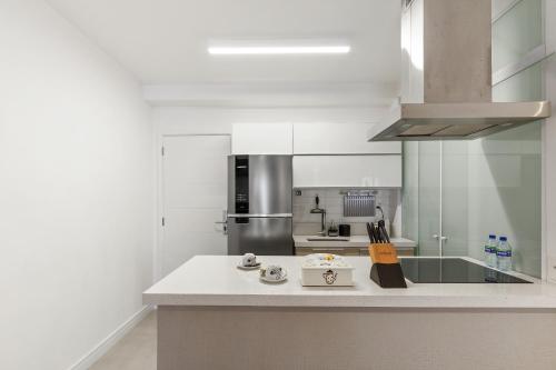 a white kitchen with a counter top and a stove at Magníficos Ap Luxo - 43mts e 63mts, 1 ou 2 Qtos in São Paulo