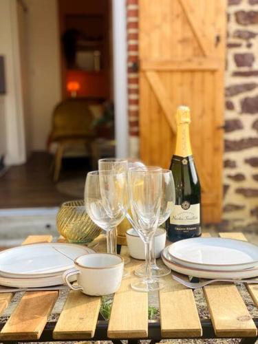 - une table avec des verres, des assiettes et une bouteille de vin dans l'établissement Sunrise - Gare & centre ville, à Rennes