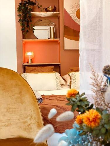 a bedroom with a bed with a mirror and flowers at Sunrise - Gare & centre ville in Rennes