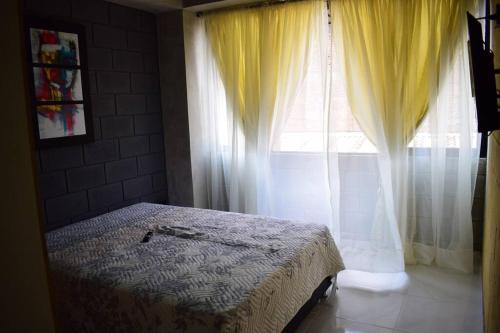 um quarto com uma cama em frente a uma janela em Apartamento en Cali em Cali