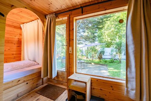 1 dormitorio con ventana en una cabaña de madera en Das Wiesenhaus: Wohnen im Tiny House direkt am Rhein en Colonia
