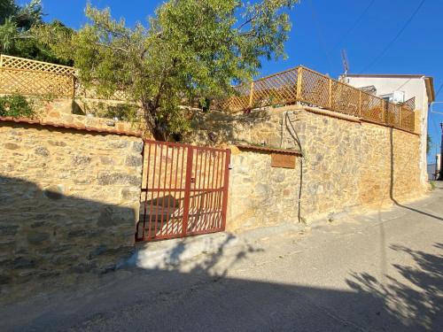 Una puerta en una pared de piedra con un árbol detrás. en Casa di Fragkiskos. Ένα σπίτι μέσα στη φύση., en Kondomárion