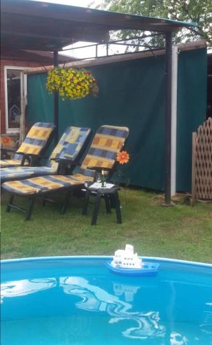 a group of chairs sitting next to a swimming pool at Ferienwohnung ILSENHOF in Königsbrück