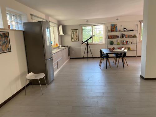a kitchen with a refrigerator and a table with chairs at Alloggio turistico Villa Camelia Lavinio in Anzio