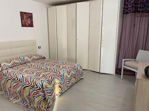 a bedroom with a bed with a colorful blanket on it at Alloggio turistico Villa Camelia Lavinio in Anzio