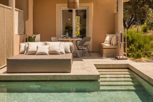 a couch sitting next to a swimming pool at Thalassa Boutique Hotel - Adults Only in Lassi