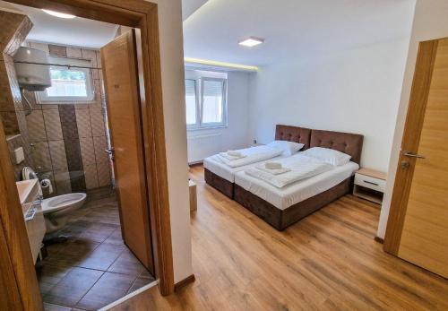 a bedroom with a bed and a bathroom with a shower at Villa Sara in Sarajevo