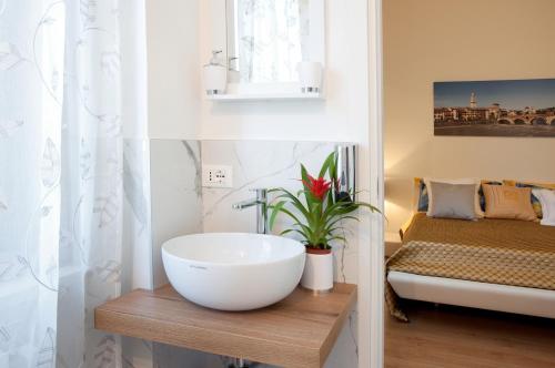 a bathroom with a white bowl sink and a bed at Arena d'Intorno in Verona