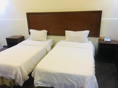 two beds in a hotel room with white sheets at ميرا سويت للشقق المخدومة in Jeddah