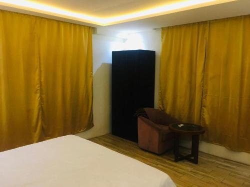 a bedroom with yellow curtains and a bed and a chair at ميرا سويت للشقق المخدومة in Jeddah