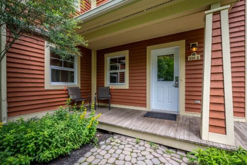 a front porch of a house with a white door at Tremblant Les Eaux by Rendez-Vous Mont-Tremblant in Mont-Tremblant