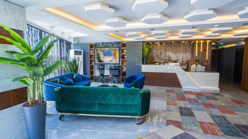 a living room with a green couch and a staircase at Luxury Airport Hotel in Arnavutköy