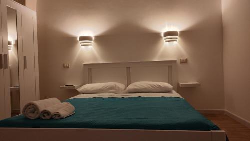 Una cama con dos toallas y dos luces por encima. en Casarù - Emozioni e relax, en Crispiano