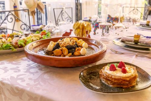 - une table avec un bol de fruits et une assiette de nourriture dans l'établissement Dar Khmissa Riad & Spa, à Marrakech