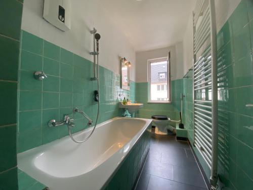 a green bathroom with a tub and a sink at Sali - E8 - WLAN, Self Check-In, 8PAX in Essen