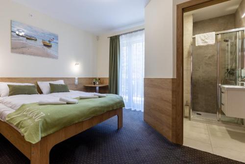 sypialnia z łóżkiem i przeszklonym prysznicem w obiekcie KIWI Sopot Apartments w mieście Sopot