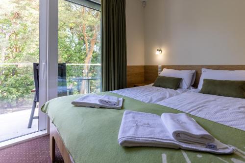 a bedroom with two beds and a large window at KIWI Sopot Apartments in Sopot