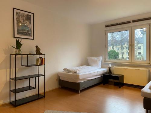 a small bedroom with a bed and a window at Sali - E8 - WLAN, Self Check-In, 8PAX in Essen