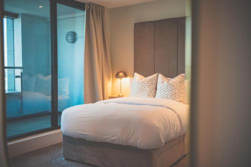 a bedroom with a large bed and a window at NOVU Apartments Liverpool Waterfront in Liverpool