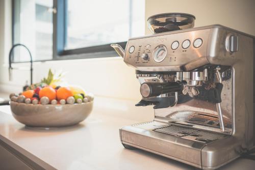 a espresso machine sitting on a counter with a bowl of fruit at NOVU Apartments Liverpool Waterfront in Liverpool