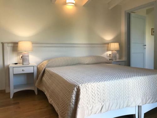 a bedroom with a bed and two lamps on tables at L'Araucaria Suite Il Ginepro in Riola Sardo