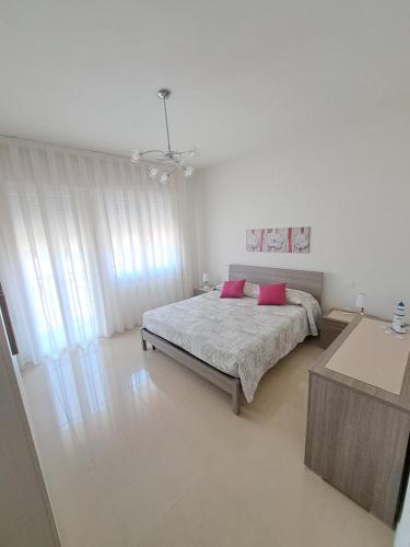a bedroom with a bed with two pink pillows at Casa Ely in Sottomarina