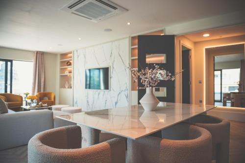 a dining room table with chairs and a vase with flowers at NOVU Apartments Liverpool Waterfront in Liverpool