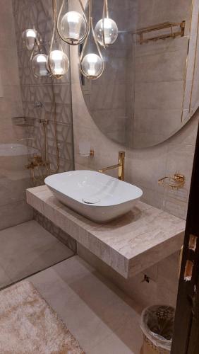 y baño con lavabo blanco y espejo. en Furnished luxury apartment, en El Cairo