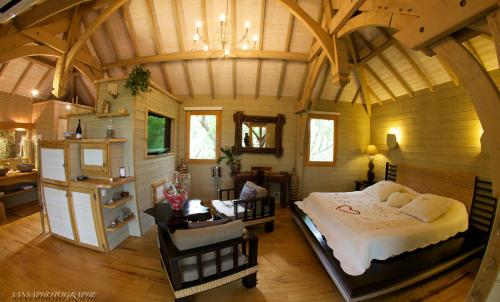 Un dormitorio con una cama grande en una habitación con techos de madera. en Cabane d'Amour, en Béziers